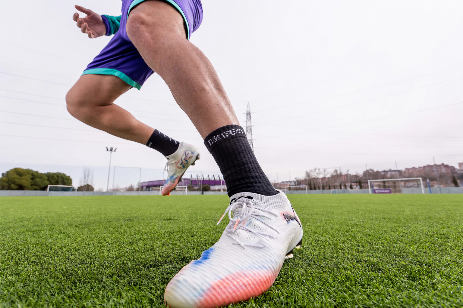 Football boot and player pivoting on the artificial turf