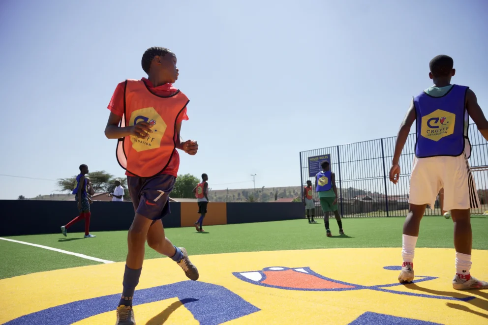 Boys playing in the sun on soccer court